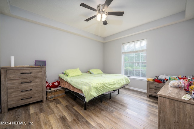 bedroom with baseboards, wood finished floors, and ceiling fan