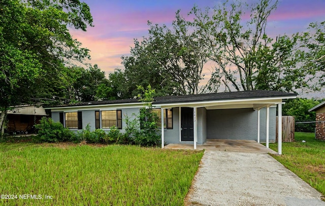 single story home featuring brick siding, driveway, and a front lawn