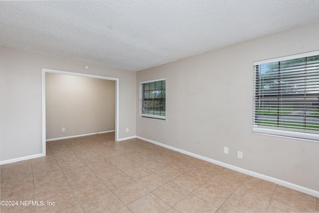 empty room with a textured ceiling and a healthy amount of sunlight