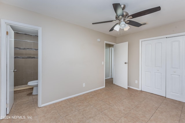 unfurnished bedroom with ensuite bath, light tile patterned floors, ceiling fan, and a closet