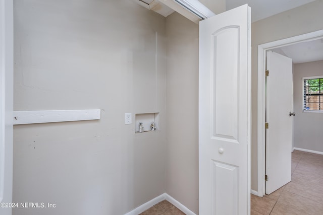 laundry room with hookup for a washing machine and light tile patterned floors