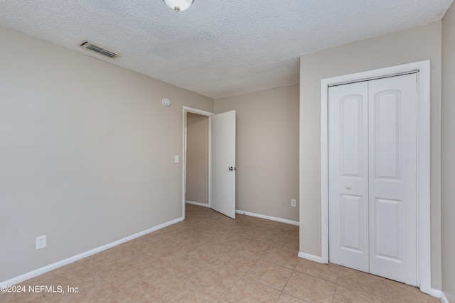 unfurnished bedroom with a closet and a textured ceiling