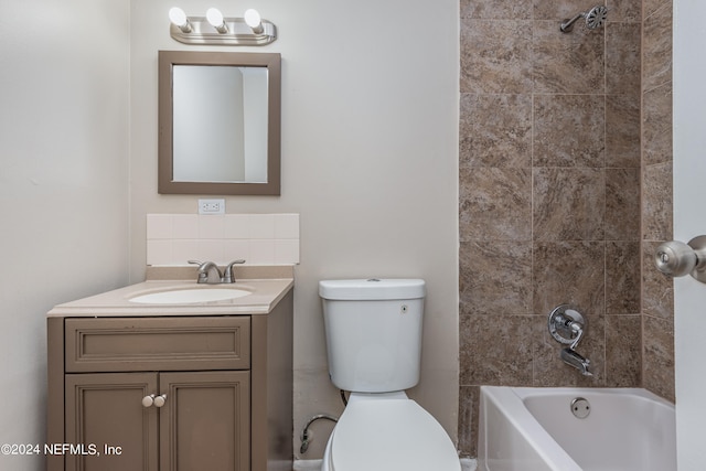 full bathroom featuring tiled shower / bath combo, vanity, and toilet