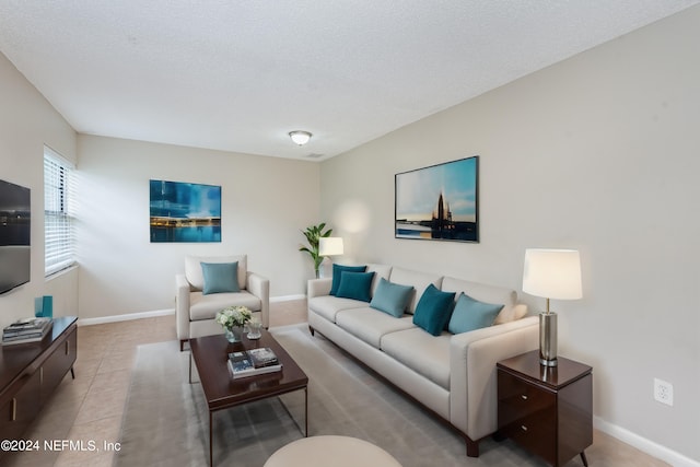 tiled living room featuring a textured ceiling