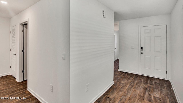 corridor with baseboards and wood finished floors