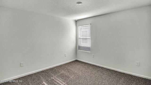 carpeted spare room featuring a textured ceiling