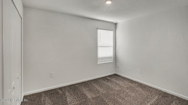 unfurnished room featuring carpet and a textured ceiling