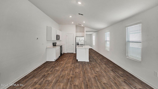 kitchen with dark wood-style floors, a center island with sink, stainless steel appliances, lofted ceiling, and light countertops