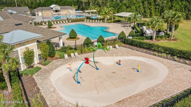 community pool with a water play area, fence, and a patio