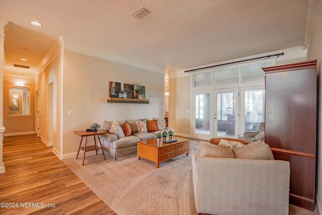 living room with ornamental molding, hardwood / wood-style floors, and a textured ceiling