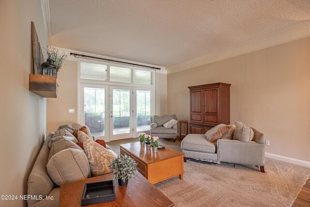 living room featuring ornamental molding, a textured ceiling, and french doors