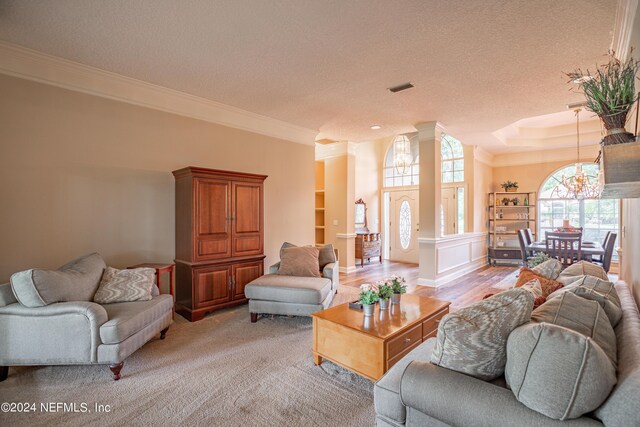 living room with crown molding, a chandelier, and a textured ceiling