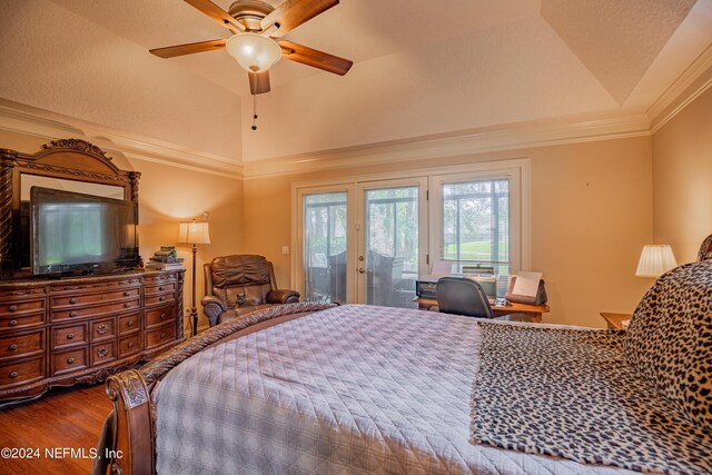 bedroom with lofted ceiling, access to outside, ornamental molding, a tray ceiling, and hardwood / wood-style flooring