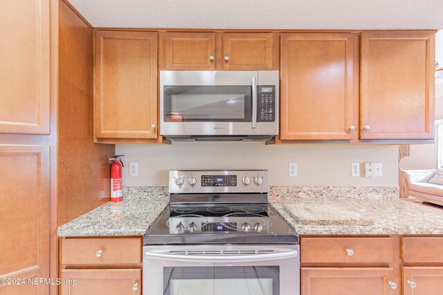 kitchen featuring light stone countertops and appliances with stainless steel finishes