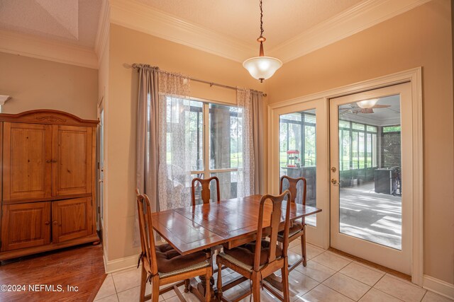 dining area with crown molding, light tile patterned flooring, and french doors