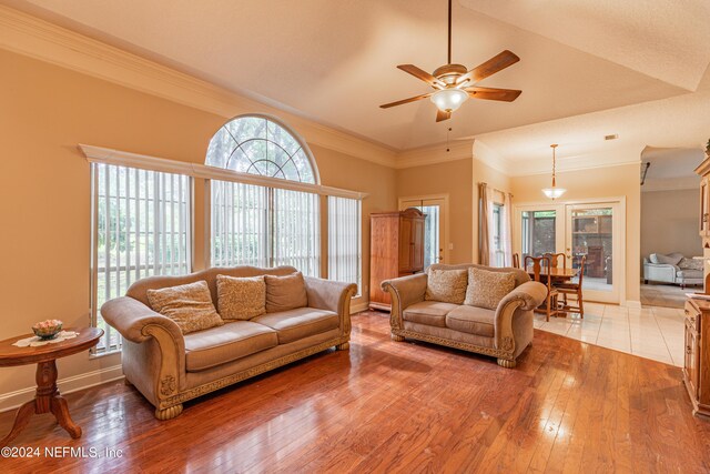 living room featuring ornamental molding, ceiling fan, and light wood-type flooring