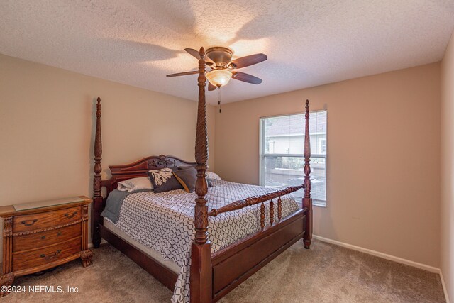 bedroom featuring light colored carpet, a textured ceiling, and ceiling fan