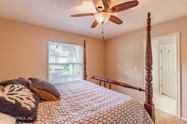 carpeted bedroom with ceiling fan and a textured ceiling