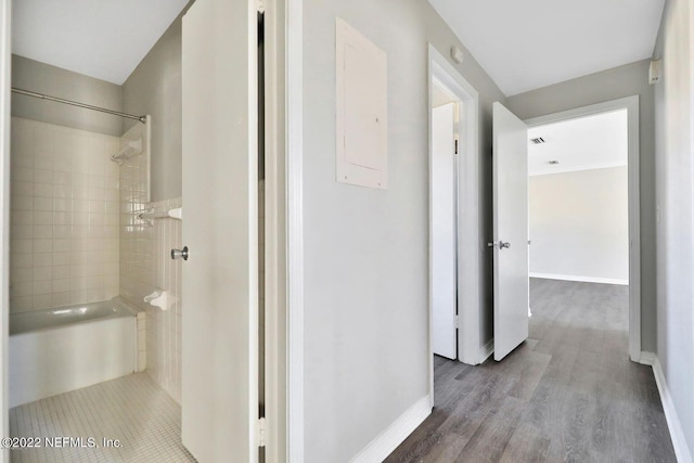 corridor with baseboards and wood finished floors