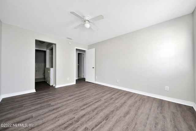 unfurnished bedroom featuring ensuite bath, baseboards, ceiling fan, and wood finished floors