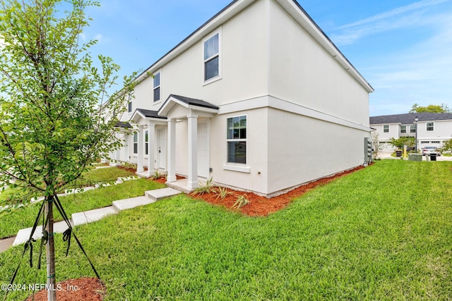 exterior space featuring a front lawn and stucco siding