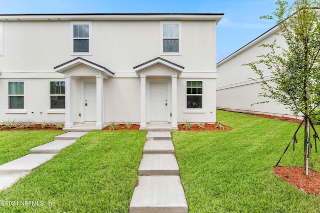 view of front facade with a front yard and stucco siding