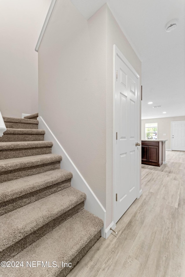 staircase featuring wood-type flooring