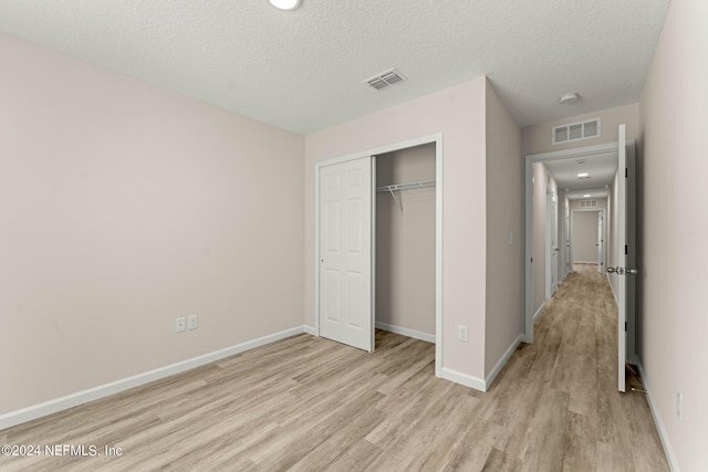 unfurnished bedroom with visible vents, light wood-style flooring, and baseboards