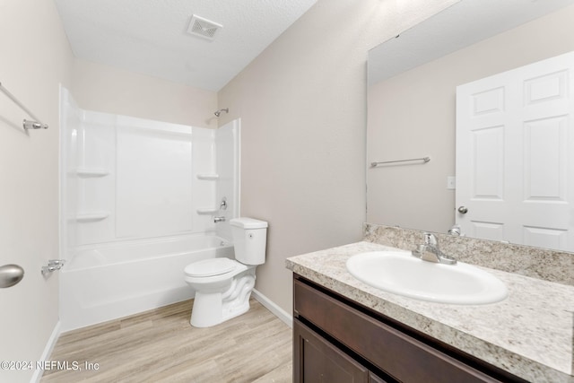 full bathroom with shower / bath combination, vanity, a textured ceiling, wood-type flooring, and toilet