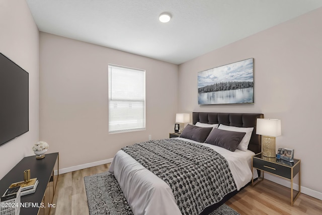 bedroom featuring light wood-style flooring and baseboards