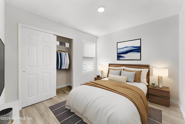 bedroom with light hardwood / wood-style floors and a closet