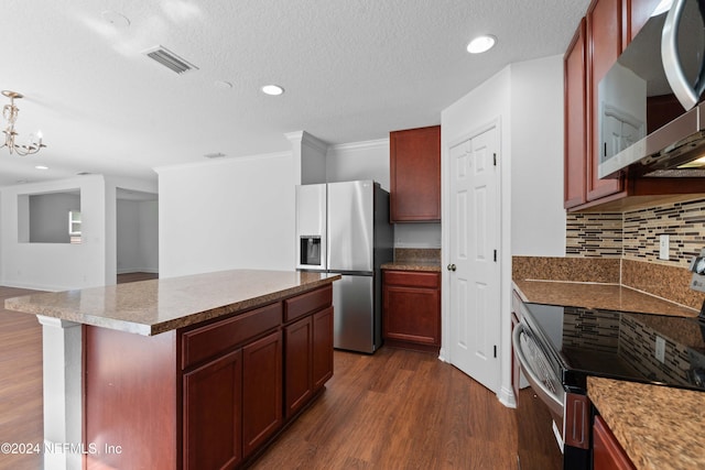 kitchen featuring decorative backsplash, a kitchen island, appliances with stainless steel finishes, dark wood-type flooring, and crown molding