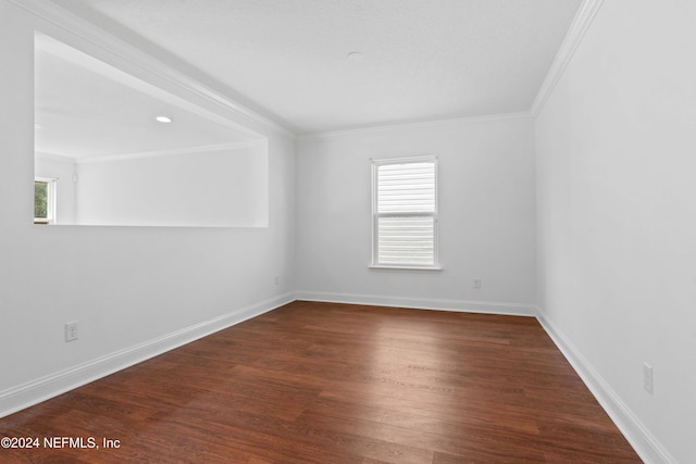 unfurnished room with ornamental molding and dark hardwood / wood-style floors