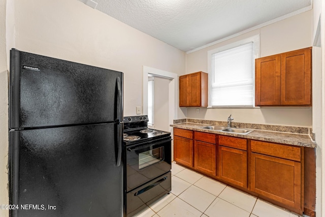 kitchen featuring black appliances, a textured ceiling, light tile patterned floors, and sink