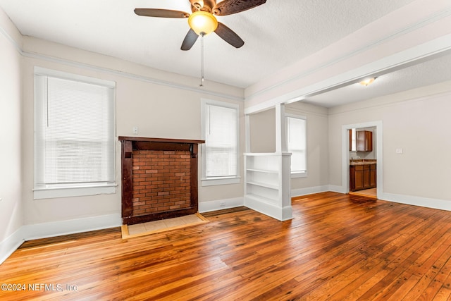 unfurnished living room with hardwood / wood-style floors, ceiling fan, and a textured ceiling