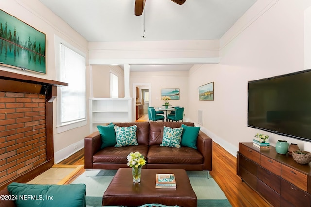 living room with hardwood / wood-style floors, ceiling fan, and ornamental molding