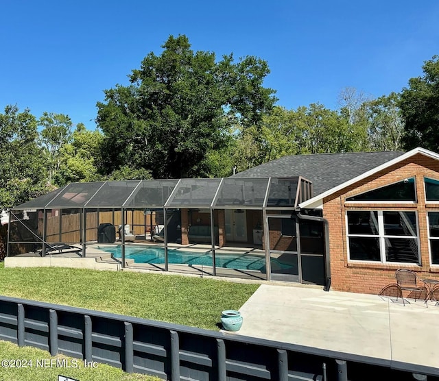 back of house with brick siding, a yard, a patio, glass enclosure, and an outdoor pool