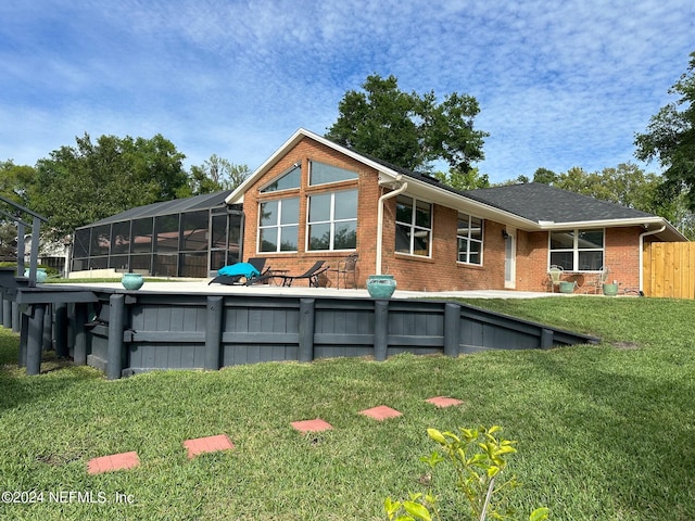 back of house with a lawn and brick siding