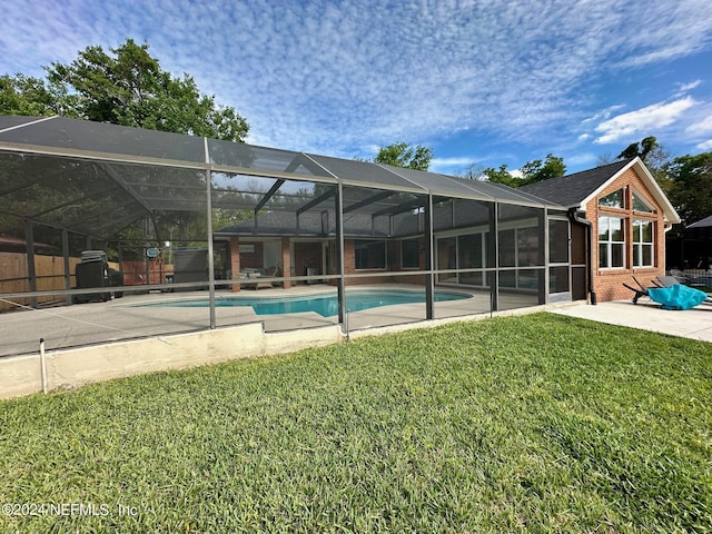 pool with glass enclosure, a lawn, and a patio area