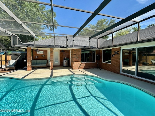 outdoor pool with a patio area, ceiling fan, and glass enclosure