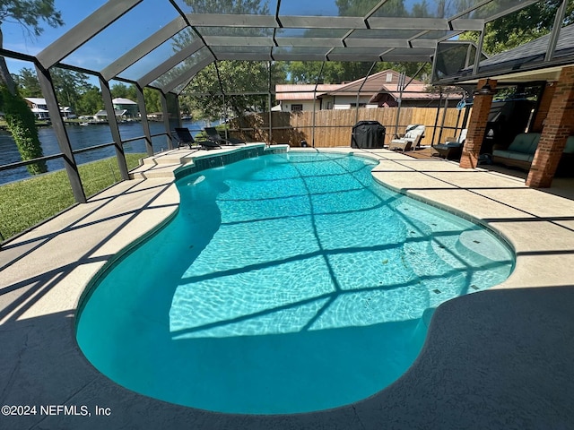 view of pool with a patio area, fence, a fenced in pool, and a lanai