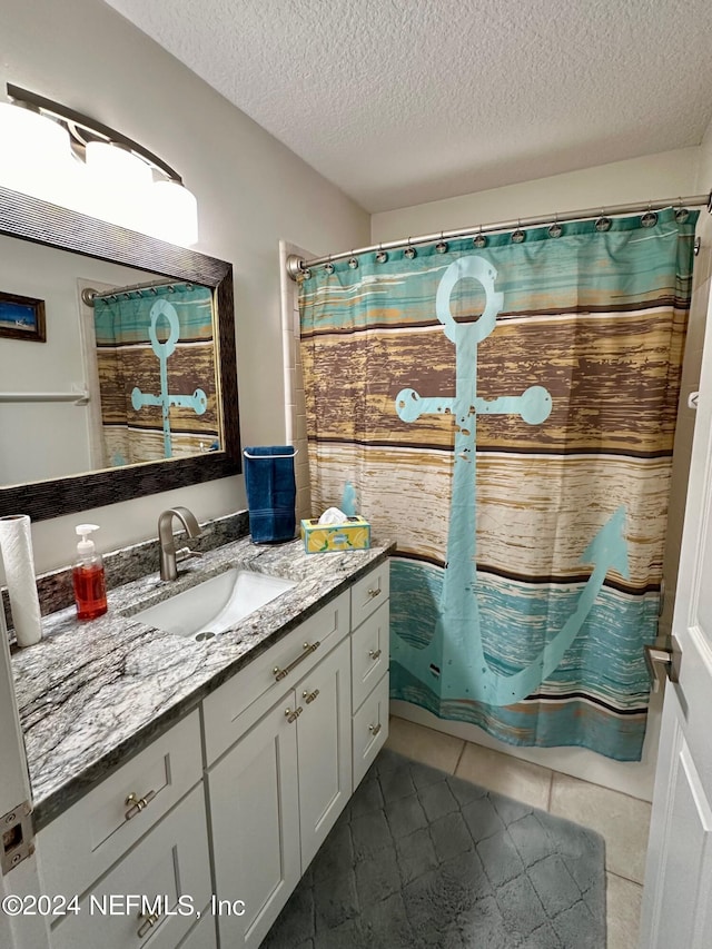 full bath featuring curtained shower, vanity, a textured ceiling, and tile patterned floors