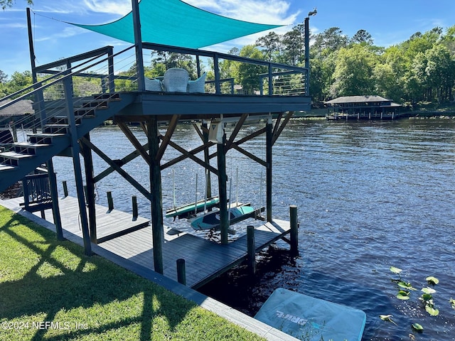 dock area featuring a water view, boat lift, and a lawn