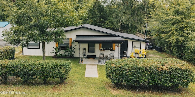 rear view of house featuring a lawn and a patio