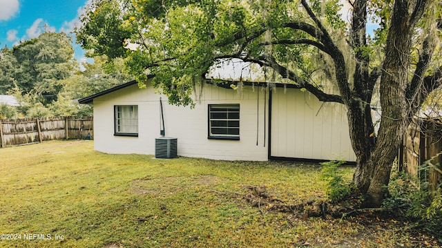 view of side of home with a yard and central air condition unit