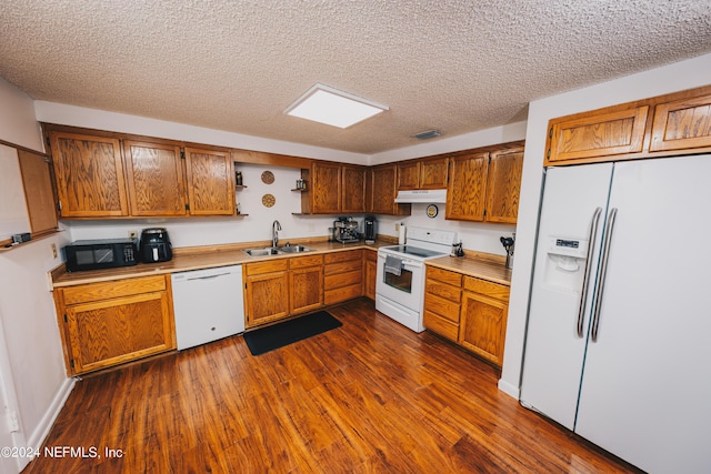 kitchen with under cabinet range hood, white appliances, dark wood-type flooring, a sink, and open shelves