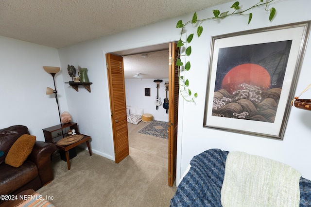 hallway featuring a textured ceiling, carpet, and baseboards