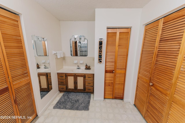 full bathroom with a closet, backsplash, a textured ceiling, vanity, and tile patterned floors