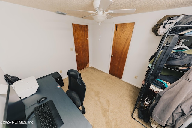 carpeted home office with a textured ceiling, ceiling fan, visible vents, and baseboards