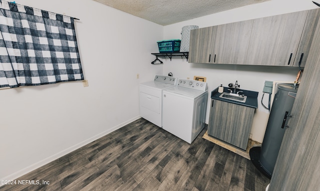 clothes washing area with a textured ceiling, water heater, washer and dryer, and dark hardwood / wood-style floors